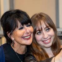 Event guest holding up her photo and taking a photo with President Mantella